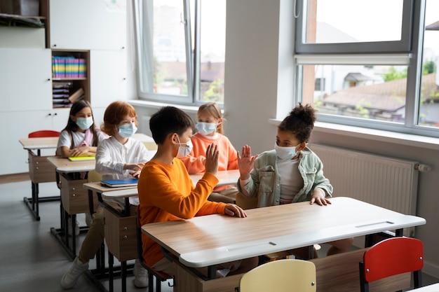 Foto gratuita estudiantes aprendiendo en la escuela en su salón de clases.