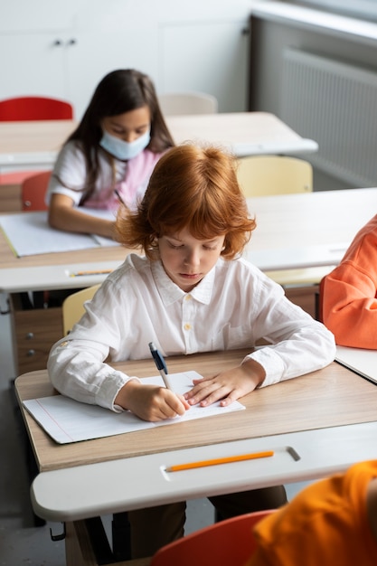 Estudiantes aprendiendo en la escuela en su salón de clases.