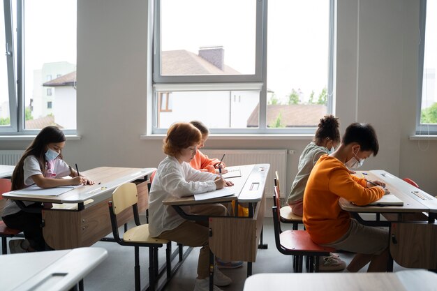 Estudiantes aprendiendo en la escuela en su salón de clases.