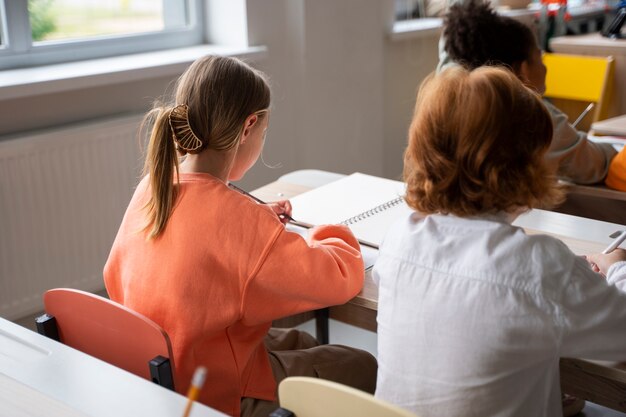 Estudiantes aprendiendo en la escuela en su salón de clases.