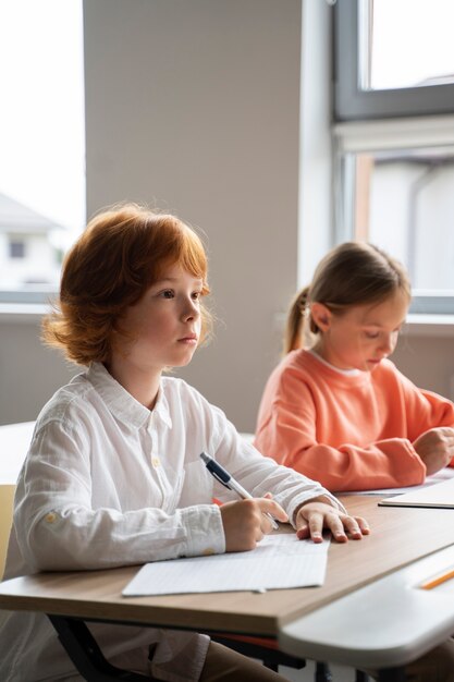 Estudiantes aprendiendo en la escuela en su salón de clases.