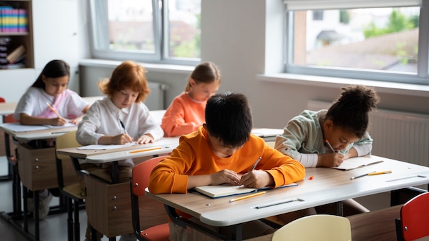 Foto gratuita estudiantes aprendiendo en la escuela en su salón de clases.