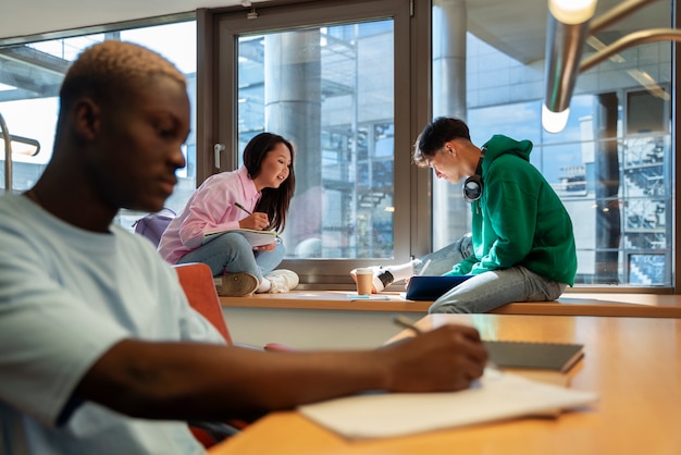 Foto gratuita estudiantes aprendiendo para la vista lateral del examen