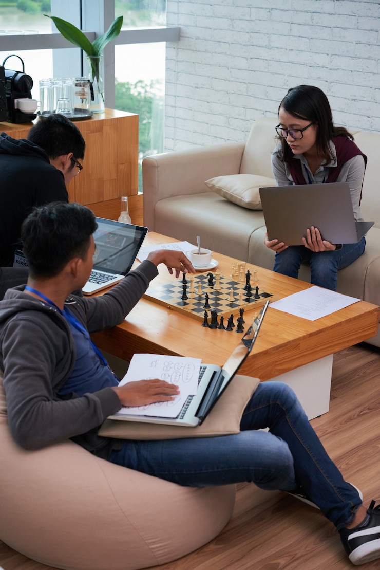 Foto gratuito estudiantes asiáticos haciendo su tarea doméstica y jugando ajedrez