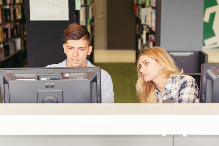 Foto gratuito estudiantes en computadoras en la biblioteca