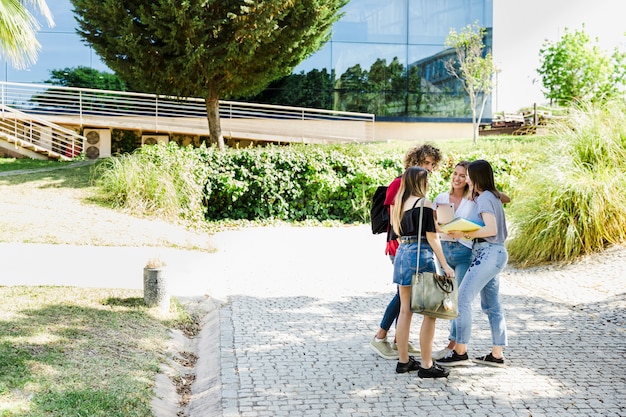 Estudiantes conversando cerca del edificio del campus