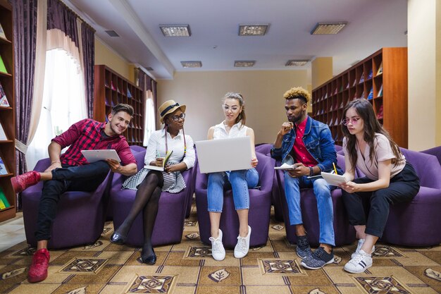 Los estudiantes creativos que colaboran con la computadora portátil