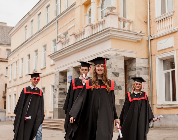 Foto gratuita estudiantes graduados caminando