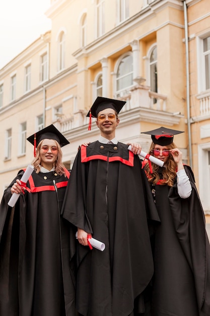 Foto gratuita estudiantes graduados felices de ángulo bajo