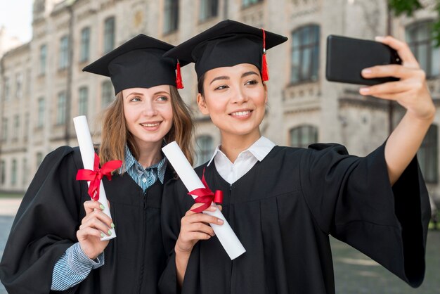 Estudiantes haciendo selfie en su graduación