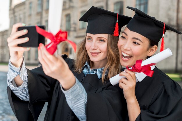 Estudiantes haciendo selfie en su graduación