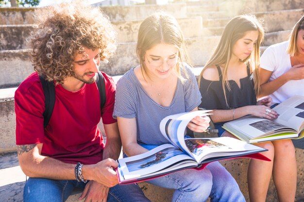 Estudiantes leyendo libros de texto en las escaleras