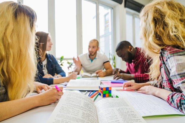 Estudiantes con libros en la mesa