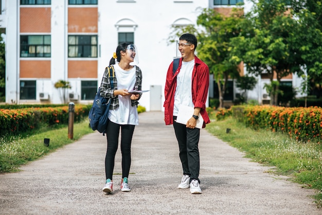 Los estudiantes masculinos y femeninos usan una cara Chill y se paran frente a la universidad.