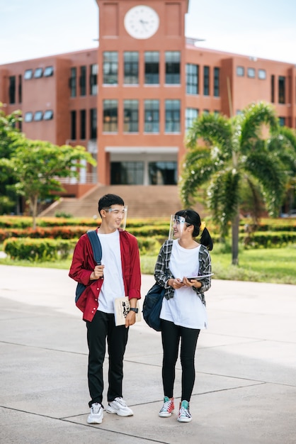 Los estudiantes masculinos y femeninos usan una cara Chill y se paran frente a la universidad.