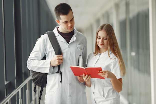 Estudiantes de medicina están leyendo un libro en la sala de un hospital