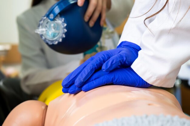 Estudiantes de medicina que practican reanimación cardiopulmonar de emergencia en una muñeca de práctica médica