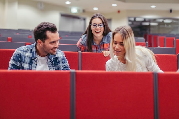 Foto gratuita estudiantes mirando algo en la sala de conferencias