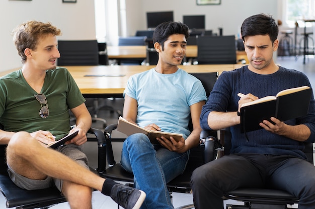 Estudiantes pensativos discutiendo notas en clase