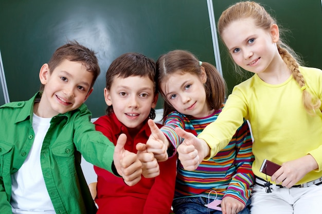 Foto gratuita estudiantes de primaria con los pulgares para arriba