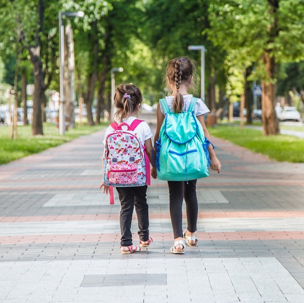 Estudiantes de primaria que llevan mochilas para ir a clase