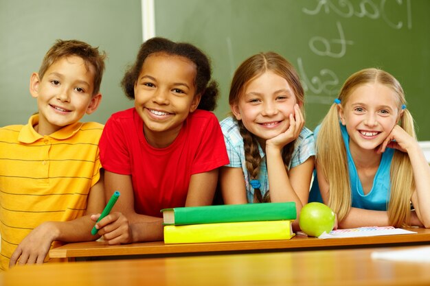 Estudiantes de primaria sonrientes sentados en clase