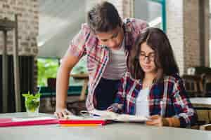 Foto gratuita estudiantes que colaboran en el libro de texto