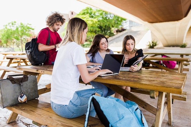 Estudiantes que estudian en la mesa en el parque