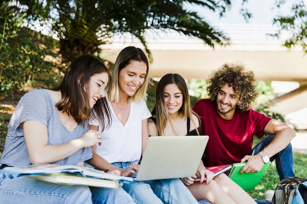 Estudiantes que usan la computadora portátil en el parque