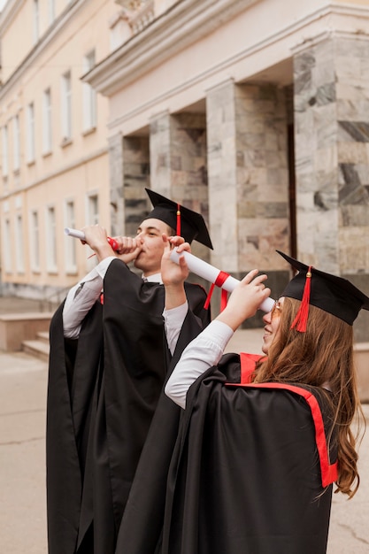 Estudiantes que usan diploma como binocular