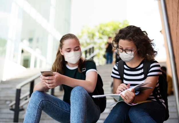 Foto gratuita estudiantes de secundaria en el nuevo estudio normal en escalera