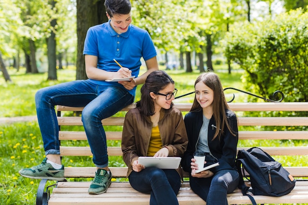 Foto gratuita estudiantes sonrientes en el banco