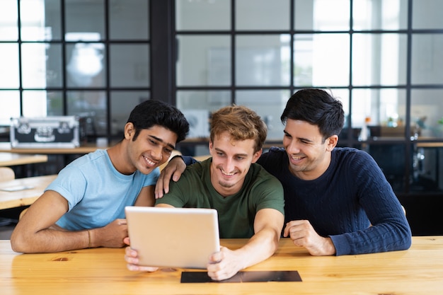 Estudiantes sonrientes mirando contenido multimedia o teniendo video llamada