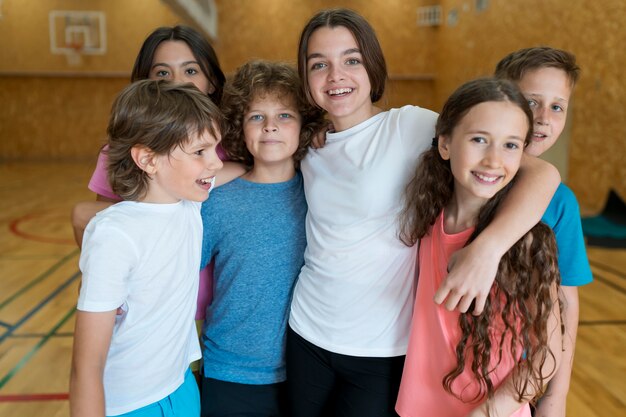 Estudiantes sonrientes de tiro medio en el gimnasio