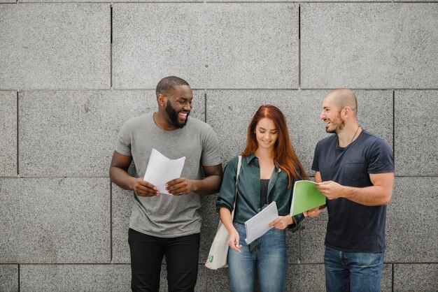 Estudiantes, tenencia, cuadernos, posición, sonriente