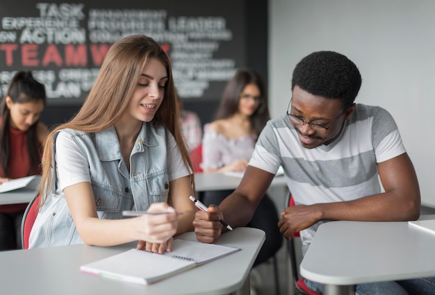 Estudiantes de tiro medio en escritorios