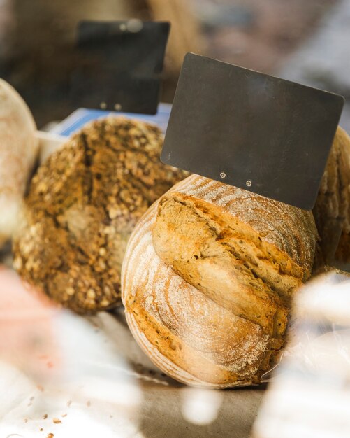 Etiqueta en blanco en pan marrón en puesto de panadería