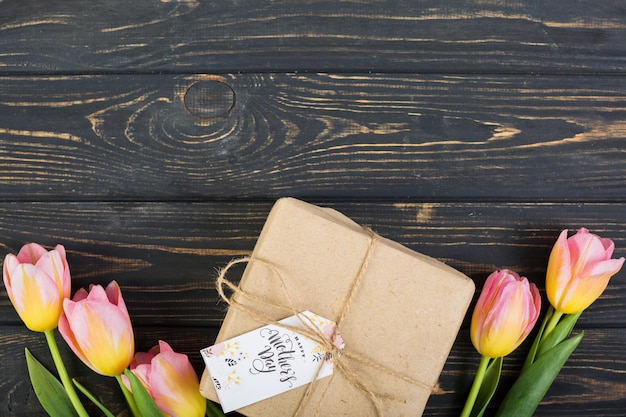 Etiqueta del día de la madre en caja de regalo alrededor de tulipanes