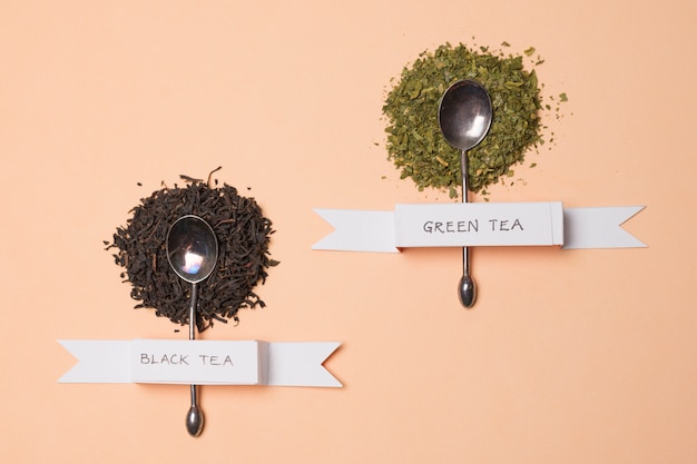 Etiqueta de té de hierbas negro y verde en las hierbas sobre el telón de fondo de melocotón