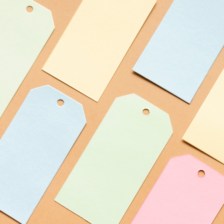 Foto gratuito etiquetas en colores pastel en hoja de cartón neutral