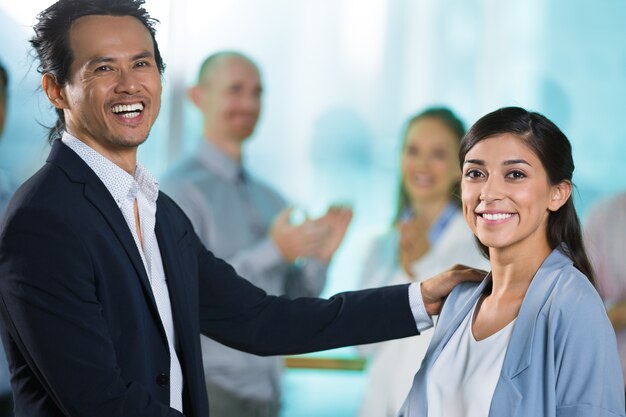 Excitado jefe felicitando a la mujer con la promoción