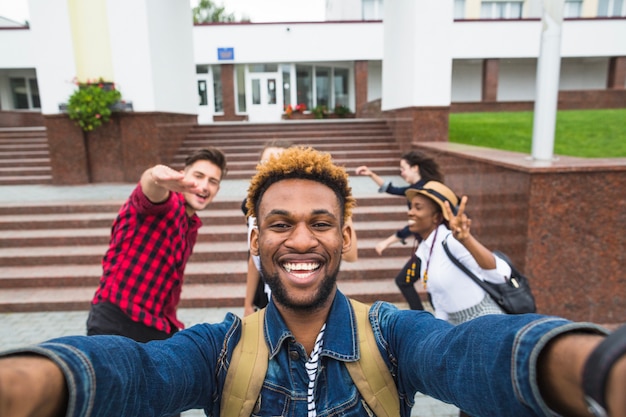 Foto gratuita excited hombre tomando selfie con compañeros de clase