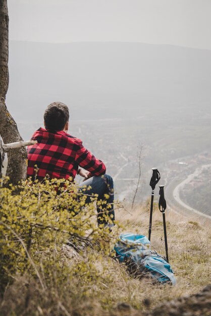 Excursionista con camisa de cuadros relajado al aire libre