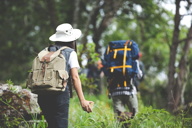 Un excursionista feliz camina por la jungla con una mochila.