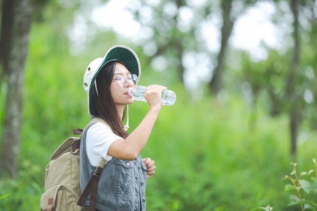 Un excursionista feliz camina por la jungla con una mochila.