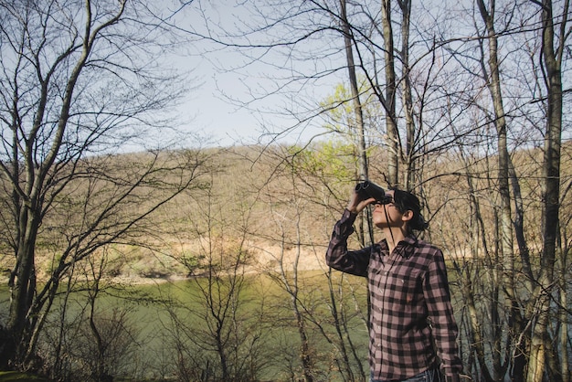 Excursionista con prismáticos en el bosque