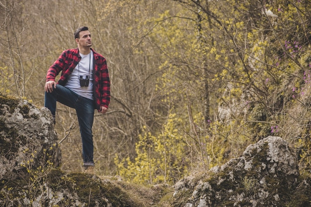 Foto gratuita excursionista relajado con el pie en una roca