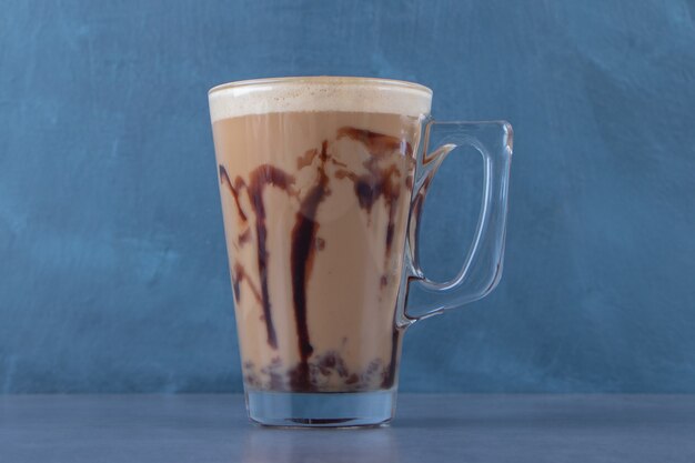 Una exhibición de capuchino de chocolate, sobre fondo azul. Foto de alta calidad