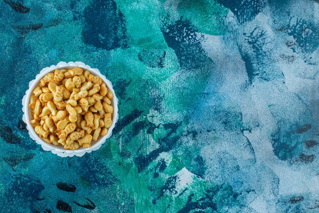 Una exhibición de galleta de pescado en un cuenco, sobre la mesa de mármol.