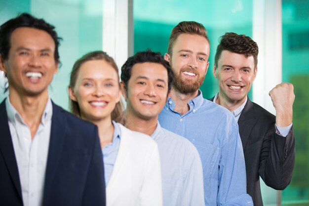 El éxito de gente sonriente de negocios se colocan en fila